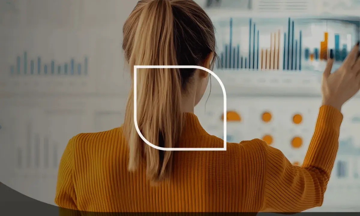 Donna con eccellenti competenze analitiche esamina grafici e dati su un grande schermo interattivo.