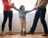 Bambina contesa tra madre e padre, un'immagine che evoca l'alienazione parentale, tema trattato anche dalla Cassazione.